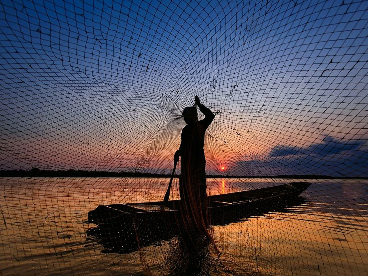 Caderno de bordo e vara de pesca sobre a mesa molhada